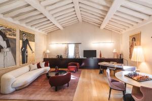 a living room with a couch and tables and chairs at Hôtel de Pavie in Saint-Émilion