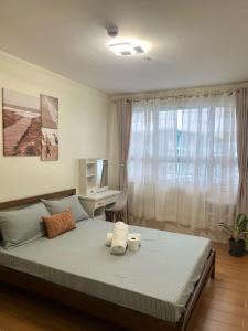 a bedroom with a bed with two towels on it at Wanderer's Home at Seawind Condo near Davao Airport in Davao City