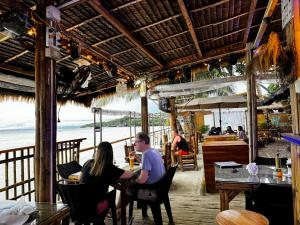 a group of people sitting at a table in a restaurant at Hydrogen Beach Bar and Resort in San Francisco