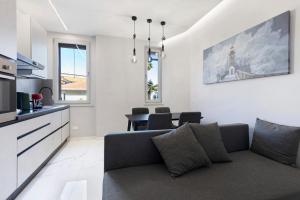 a living room with a couch and a kitchen at Dalma in Peschiera del Garda