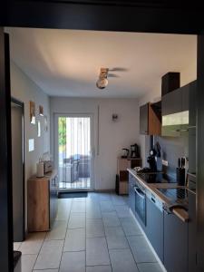 a kitchen with blue cabinets and a tile floor at Ferienwohnung Im Wiesenrain in Hausen-Wied
