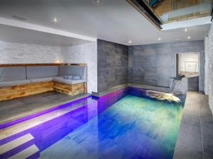 an indoor pool with colored water in a room at Chalet Colombine - OVO Network in Les Villards-sur-Thônes