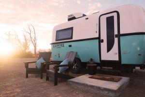 阿马戈萨山谷Tarantula Ranch Campground & Vineyard near Death Valley National Park的停在田野里的蓝色和白色大篷车