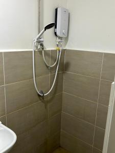 a shower in a bathroom with a phone on the wall at Ady's 737 in Kuala Lumpur