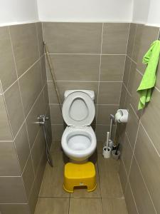 a small bathroom with a toilet with a yellow stool at Ady's 737 in Kuala Lumpur
