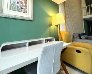 a room with a desk with a chair and a couch at April Fair Duplex Apartment Guagnzhou South Railway Station Min Jie Branch in Guangzhou