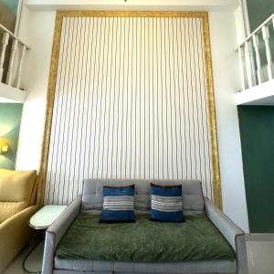 a couch with two blue pillows in a room at April Fair Duplex Apartment Guagnzhou South Railway Station Min Jie Branch in Guangzhou