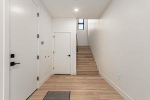 Un pasillo vacío con paredes blancas y pisos de madera. en Papago Lux Townhouse with Rooftop Lounge, en Scottsdale