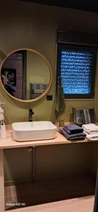 a bathroom with a sink and a mirror on a counter at Nanouchka in Médis