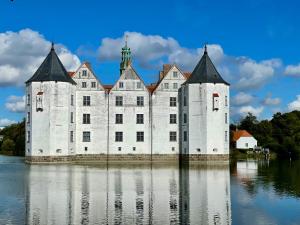 ein großes weißes Schloss im Wasser in der Unterkunft Ferienapartment schön hier in Glücksburg