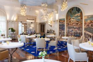 a restaurant with tables and chairs and chandeliers at Hôtel de Pavie in Saint-Émilion