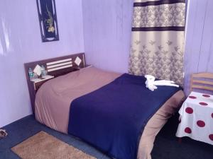 ein Schlafzimmer mit einem großen Bett und einem Tisch in der Unterkunft VINTAGE HOMES, Darjeeling in Darjeeling