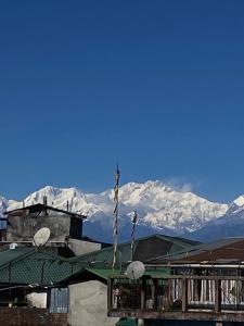 ein Gebäude mit einem Berg im Hintergrund in der Unterkunft VINTAGE HOMES, Darjeeling in Darjeeling + 13 Fotos