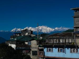 eine Gruppe von Gebäuden mit Bergen im Hintergrund in der Unterkunft VINTAGE HOMES, Darjeeling in Darjeeling