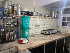 eine Küche mit einer Arbeitsplatte mit einem Herd und Tassen in der Unterkunft VINTAGE HOMES, Darjeeling in Darjeeling