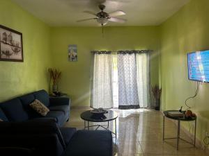a living room with a couch and a ceiling fan at J&L beachfront bliss steps to sand an sunset views in Rolleville