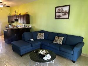 a living room with a blue couch and a table at J&L beachfront bliss steps to sand an sunset views in Rolleville