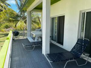a porch with two chairs and a picnic table at J&L beachfront bliss steps to sand an sunset views in Rolleville
