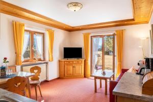 a living room with a television and a table at Alpenblick Tilly - Fewo Barmsee 2 in Krün