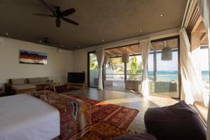 a bedroom with a bed and a view of the ocean at Casa Aakbal - Luxury Beach Front Villa in Tulum