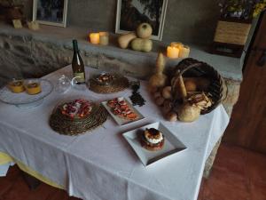 a table with food and a bottle of wine and candles at Rectoria Santuari del Coll in Girona