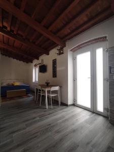 Habitación con mesa, sillas y puerta corredera en Antignano mare LOFT, en Livorno