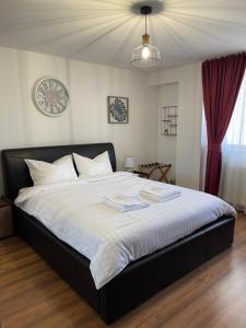 a bedroom with a large bed with a clock on the wall at Ultra Central View in Alba Iulia