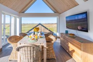 a dining room with a table and chairs and a television at The Ark 4 in Southwold