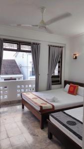 a bedroom with a large bed and a large window at Gray Stone homestay in Hoi An