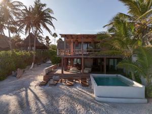 a house on the beach with a swimming pool at Casa Aakbal - Luxury Beach Front Villa in Tulum