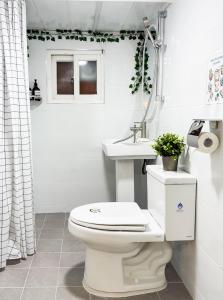 Un baño blanco con inodoro y lavabo. en Momentree Stay, en Seúl 44 fotos más