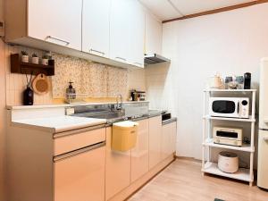 una cocina con fregadero y microondas en Momentree Stay, en Seúl