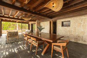 a dining room with a wooden table and chairs at Casa Aakbal - Luxury Beach Front Villa in Tulum