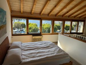 a bedroom with a bed in a room with windows at Osteria Ascona in Ascona