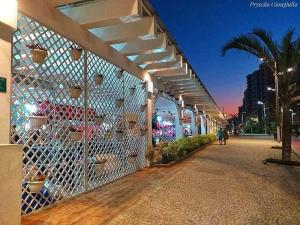 大普拉亚apartamento praia grande sp的一栋有围栏的建筑物和一名在街上行走的人