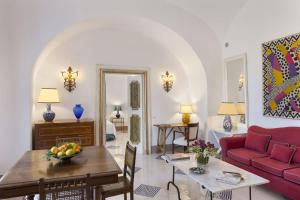 a living room with a red couch and a table at Torre Sponda - Cisterna, Private Beach in Positano