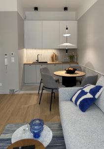 オルシュティンにあるApartament Premium nad jeziorem, przy samej plaży miejskiejのソファとテーブルのあるリビングルーム