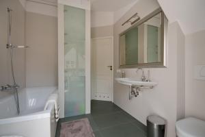 łazienka z wanną, umywalką i lustrem w obiekcie Imperial Apartments - Galeria w mieście Sopot +25 zdjęć