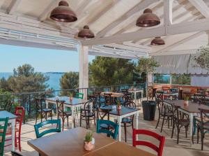 波雷奇Valamar Camping Lanterna - Roan的一间带桌椅的餐厅以及一个阳台