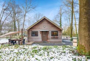 a small cabin in the woods with snow on the ground at Cabane Colette in Ieper
