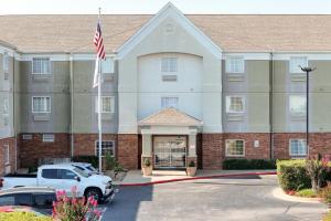 タルサにあるAffordable Suites of America Tulsaの駐車場内のアメリカ旗の建物