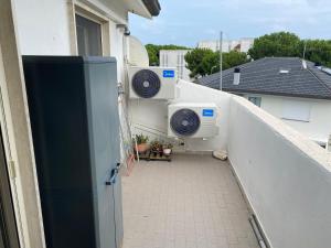 Villa RosaにあるRosa houseの建物の脇に洗濯機が2台置かれたバルコニー