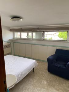 Villa RosaにあるRosa houseのベッドと椅子が備わる小さな客室です。