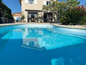 Una gran piscina azul frente a una casa en La Valenzo, en Aubagne