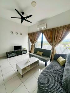 Una sala de estar con un sofá y un ventilador de techo. en Family Homestay, en Nilai