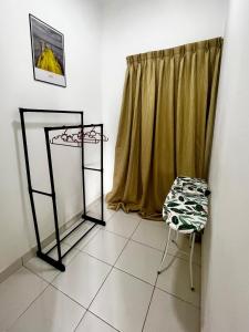 Una habitación con una silla y una ventana con una cortina. en Family Homestay, en Nilai 8 fotos más