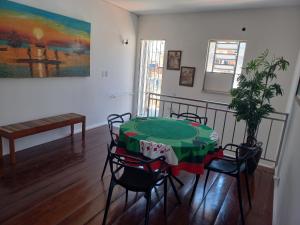 a dining room with a green table and chairs at Hostel Rota do Sol in Cabo Frio