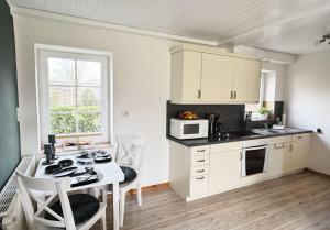une cuisine avec une table et des chaises et un micro-ondes dans l'établissement Ferienhof-Wohler-Wohnung-2, à Bojendorf