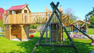 une aire de jeux en bois avec une maison en bois au-dessus dans l'établissement Ferienhof-Wohler-Wohnung-2, à Bojendorf