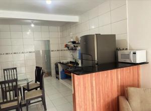 a kitchen with a refrigerator and a table with chairs at Wcasadepraia in Maragogi